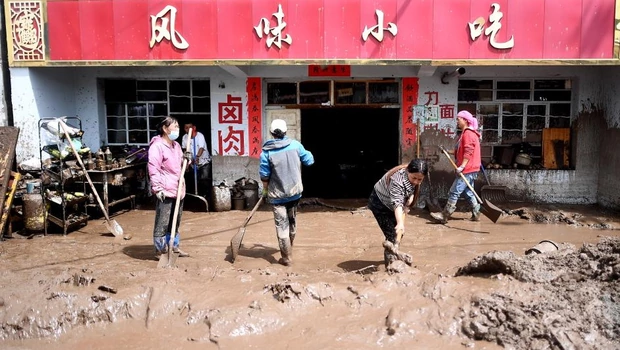 Penduduk setempat membuang lumpur dari properti mereka di Kotapraja Qingshan di Datong Hui dan Kabupaten Otonom Tu di Provinsi Qinghai, Tiongkok barat laut, Kamis 18 Agustus 2022.