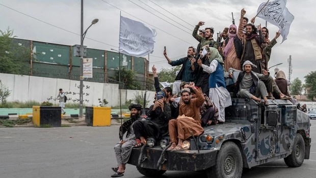 Pejuang Taliban memegang senjata saat mereka naik humvee untuk merayakan hari kemenangan mereka di dekat kedutaan AS di Kabul, Afghanistan pada Senin 15 Agustus 2022.