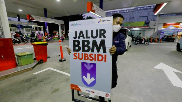 Petugas memindahkan petunjuk jalur bbm bersubsidi di salah satu SPBU Pertamina di Jakarta.