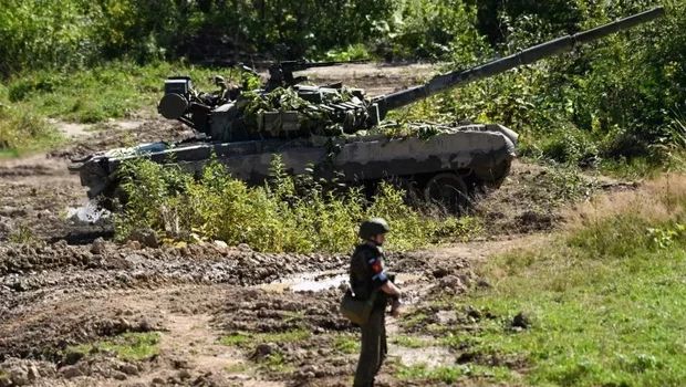Seorang tentara melihat satu tank yang mengambil bagian dalam latihan militer di tempat pelatihan Uspenovskyi di luar kota Yuzhno-Sakhalinsk di Timur Jauh Rusia pada Minggu 4 September 2022. 