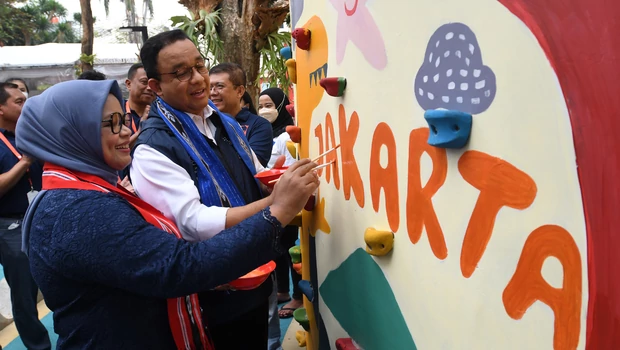 Gubernur DKI Jakarta Anies Baswedan (kanan) dan istrinya Fery Farhati mewarnai tulisan 'Jakarta' saat peresmian Taman Literasi Martha Christina Tiahahu di Blok M, Jakarta Selatan, Minggu, 18 September 2022.