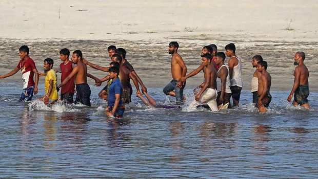 Orang-orang mengevakuasi mayat korban yang meninggal setelah satu perahu terbalik di sungai Karotoa dekat kota Boda, Bangladesh pada Senin 26 September 2022. 