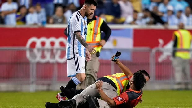 Seorang fan dijatuhkan petugas saat ingin selfie dengan Lionel Messi dalam pertandingan uji coba Argentina melawan Jamaica, di New Jersey, Amerika Serikat, Selasa, 28 September 2022.