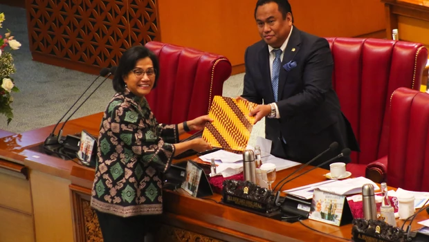 Menteri Keuangan Sri Mulyani menyerahkan dokumen kepada Wakil Ketua DPR Rachmat Gobel dalam rapat paripurna DPR di kompleks Parlemen, Senayan, Jakarta, Kamis, 29 September 2022.