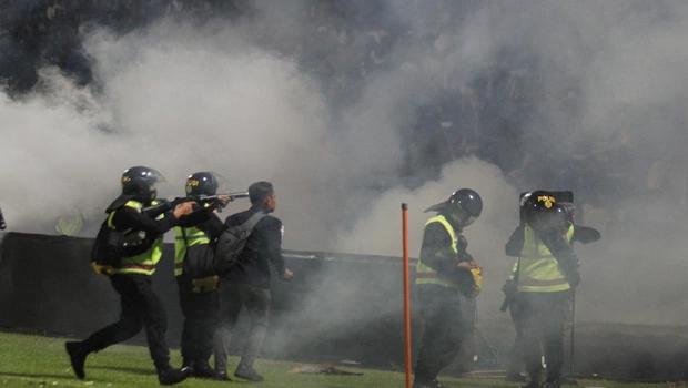 Aparat keamanan menembakkan gas air mata untuk menghalau suporter yang masuk lapangan usai pertandingan sepak bola Liga 1 antara Arema melawan Persebaya di Stadion Kanjuruhan, Malang, Sabtu, 1 Oktober 2022.