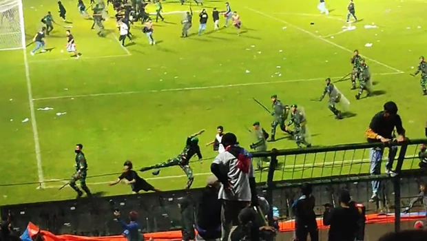Aparat keamanan mengusir suporter yang masuk lapangan di Stadion Kanjuruhan, Malang, Jawa Timur, Sabtu, 1 Oktober 2022 malam. Tragedi Kanjuruhan ini menewaskan sekurangnya 127 suporter.