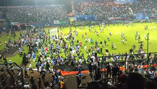 Aparat keamanan mengusir suporter yang masuk lapangan di Stadion Kanjuruhan, Malang, Jawa Timur, Sabtu, 1 Oktober 2022 malam. Tragedi Kanjuruhan ini menewaskan sekurangnya 127 suporter.