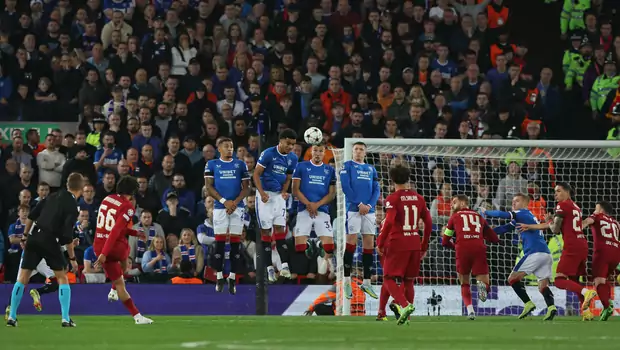 Bek Liverpool, Trent Alexander-Arnold (kiri) mengeksekusi tendangan bebas yang menghasilkan gol ke gawang Rangers dalam partai Liga Champions, Selasa, 4 Oktober 2022. 