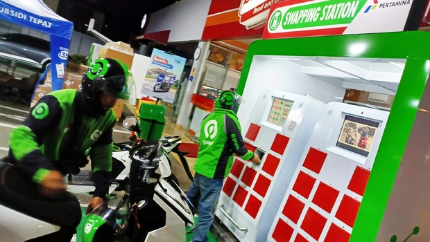 Pengemudi ojek daring mengganti baterai sepeda motor listrik di Stasiun Penukaran Baterai Kendaraan Listrik Umum (SPBKLU) di SPBU Pertamina, Jalan Cipete, Jakarta, Jumat 7 Oktober 2022.