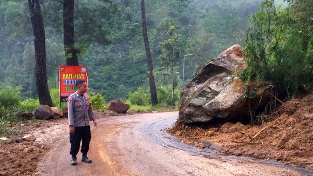 Polisi mengamankan jalur yang sebelumnya terdampak bencana longsor di Pamulihan, Kabupaten Garut, Jawa Barat, Jumat 25 November 2022.