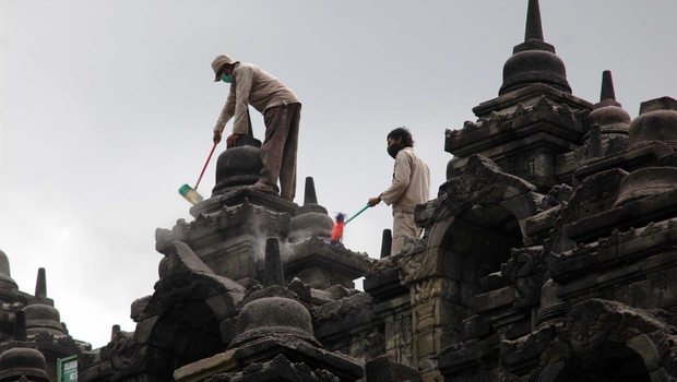 Para pekerja membersihkan Candi Borobudur dari abu vulkanik