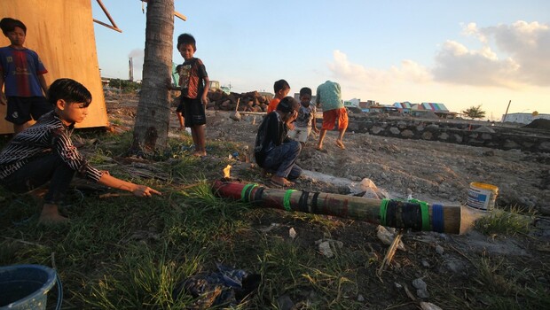 Anak-anak bermain meriam bambu.
