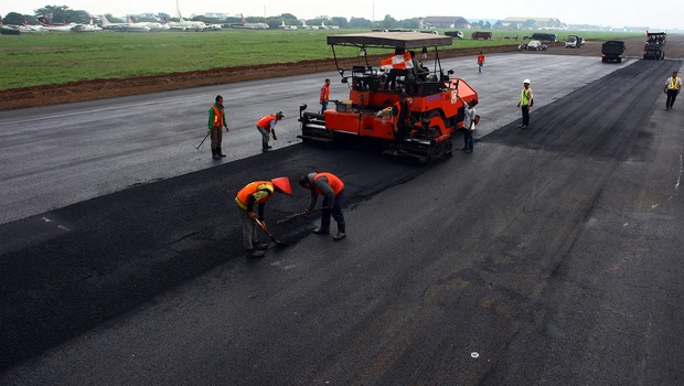 Pekerja melakukan pengaspalan ulang landasan pacu Bandara Pondok Cabe, Pamulang, Tangerang Selatan, Banten, 3 Desember 2015. Antara/Muhammad Iqbal