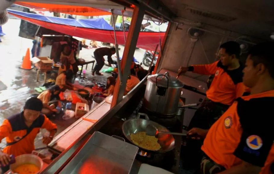 Sejumlah relawan yang terdiri dari mahasiswa, TNI dan Siswa SMU sibuk memasak di dapur umum Pusat Pengendalian dan Operasi Badan Penanggulangan Bencana (Pusdalops BPBD) DKI di kampus Binawan, Cawang, Jakarta Timur, Rabu (22/1). SP/Joanito De Saojoao.