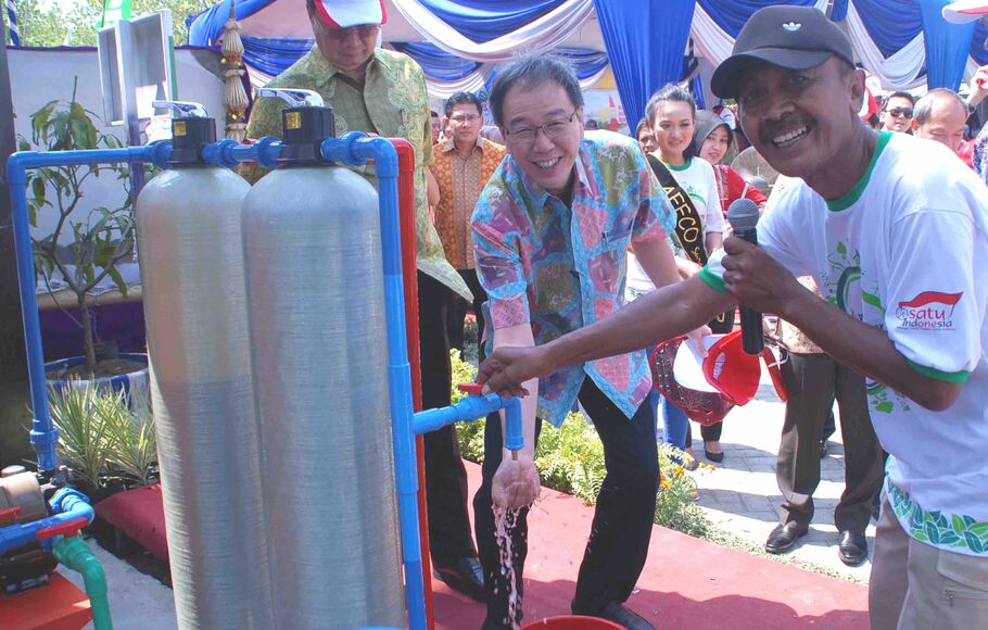Presdir PT Astra International Tbk Prijono Sugiarto (tengah) mengetes air Water Treatment Plant (WTP) saat peresmian Kampung Berseri Astra di Kampung Keputih Tegal Timur, Surabaya, Jawa Timur, 14 Oktober 2014.
