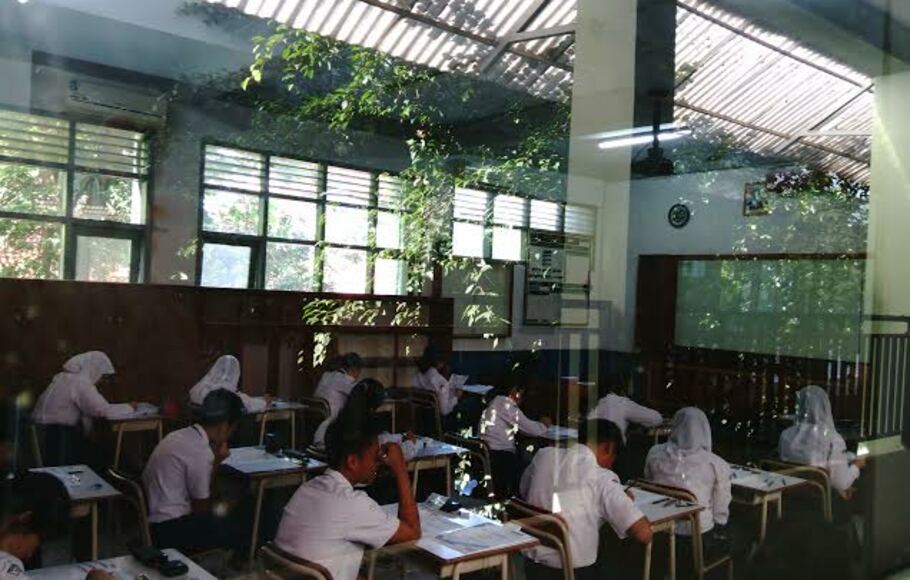 Peserta ujian nasional tingkat sekolah menengah pertama nampak serius mengerjakan soal bahasa Indonesia di SMP Negeri 1,Kota Bogor, Senin, 4 Mei 2015.