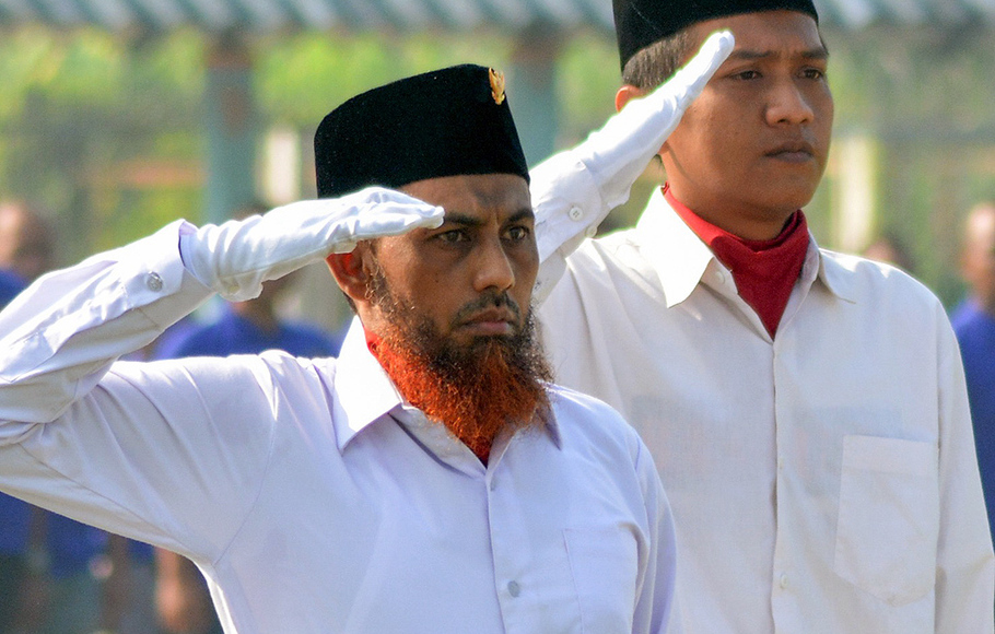 Terpidana kasus terorisme Umar Patek (kiri) memberi hormat ketika menjadi pengibar bendera merah putih pada upacara memperingati Hari Kebangkitan Nasional (Harkitnas) di Lapas Porong, Sidoarjo, Jawa Timur, 20 Mei 2015. Antara/Umarul Faruq