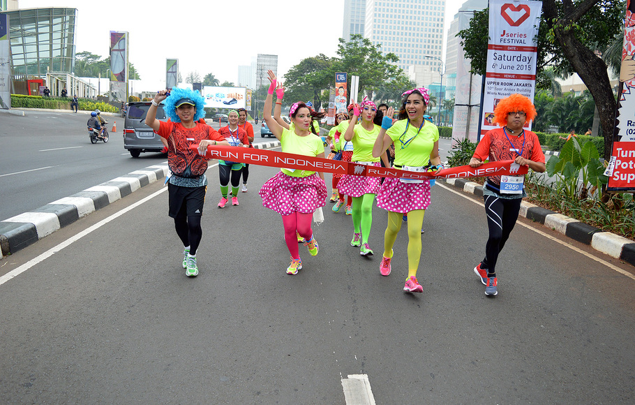 Sejumlah peserta berlari mengenakan kostum warna-warni dalam rangka mengikuti acara 