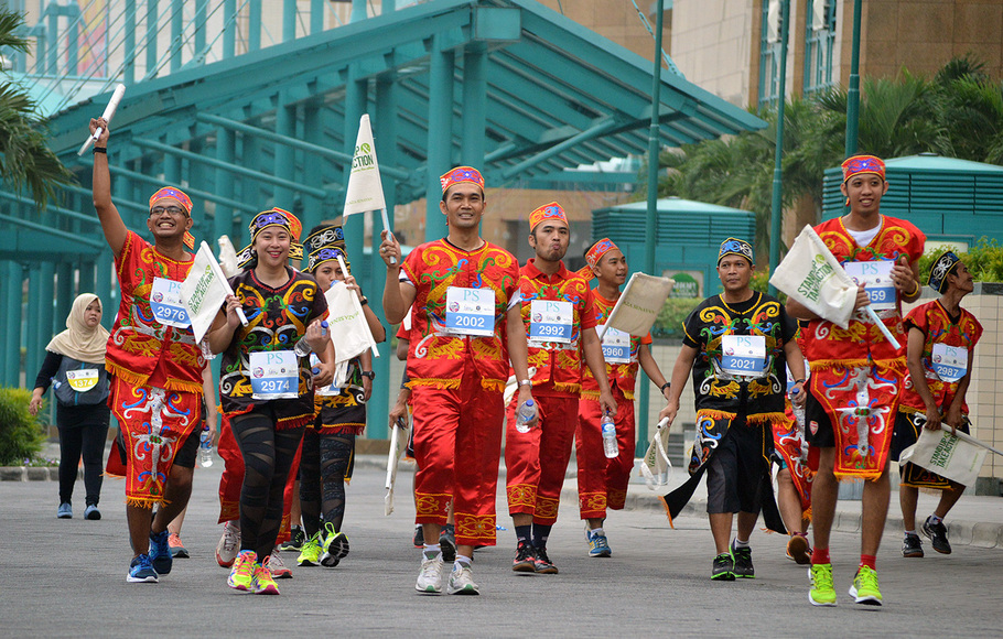 Sejumlah peserta berlari mengenakan pakaian adat Nusantara dalam rangka mengikuti acara 