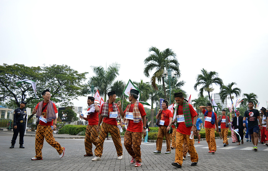 Sejumlah peserta berlari mengenakan pakaian adat khas Betawi dalam rangka mengikuti acara 