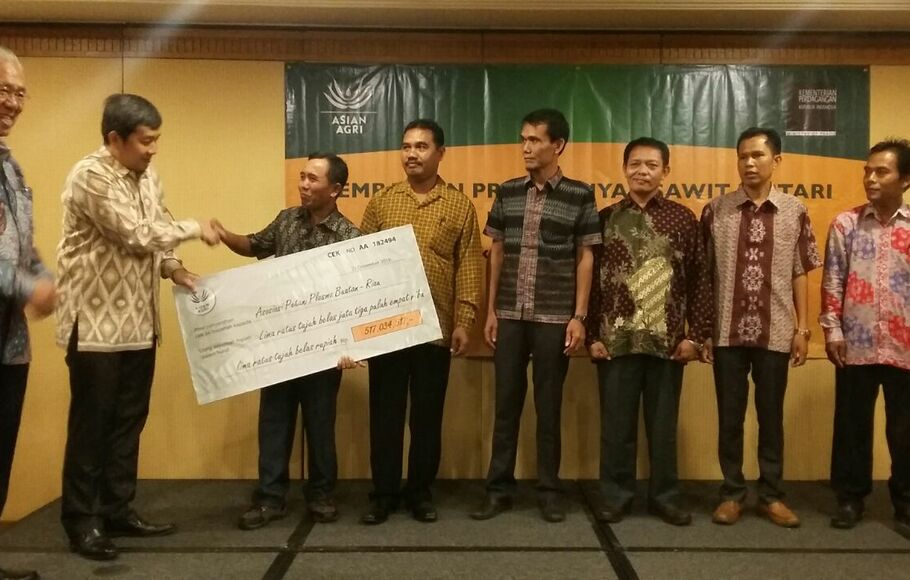 Menteri Perdagangan Enggartiasto Lukita (kanan) menyaksikan pemberian premi kepada para petani plasma binaan Asian Agri oleh Direktur Asian Agri Freddy Widjaya (kedua dari kanan) di Jakarta, Rabu (21/12)