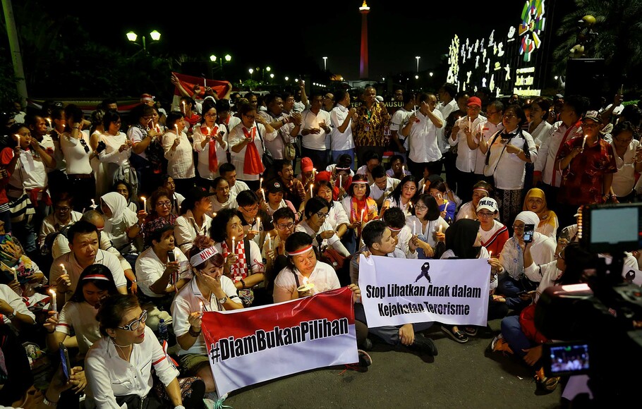 Warga Jakarta menyalakan lilin saat mengikuti aksi solidaritas terhadap korban bom Surabaya, di depan pintu masuk Silang Monas, Jakarta, Selasa 15 Mei 2018.