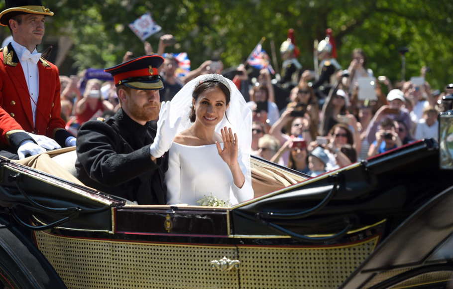 Pangeran Harry dan istrinya, Putri Meghan Markle pawai di atas kereta kuda dalam rangkaian acara pernikahan keduanya di Inggris, 19 Mei 2018 waktu setempat.