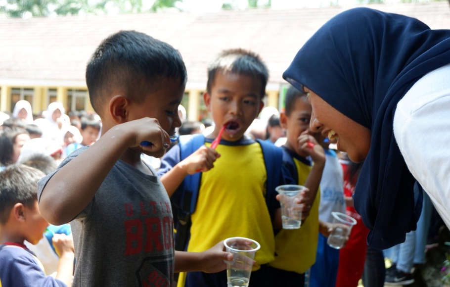 Seorang penerima beasiswa LPDP sedang mengajari anak menggosok gigi yang benar, di SD desa Cimulang, Bogor. 