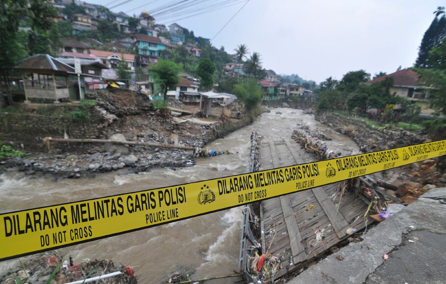 Garis polisi ditempatkan di jembatan yang rusak setelah hujan lebat dan mengakibatkan tanah longsor di Bogor, Jawa Barat pada 28 April 2019.