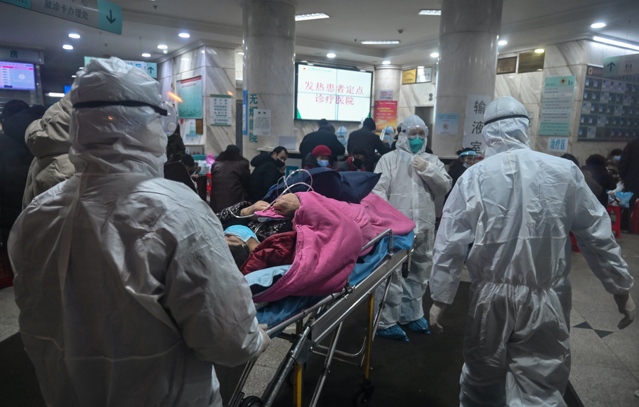 Petugas membawa pasien yang diduga tertular virus korona di Rumah Sakit Palang Merah Wuhan, Tiongkok. 