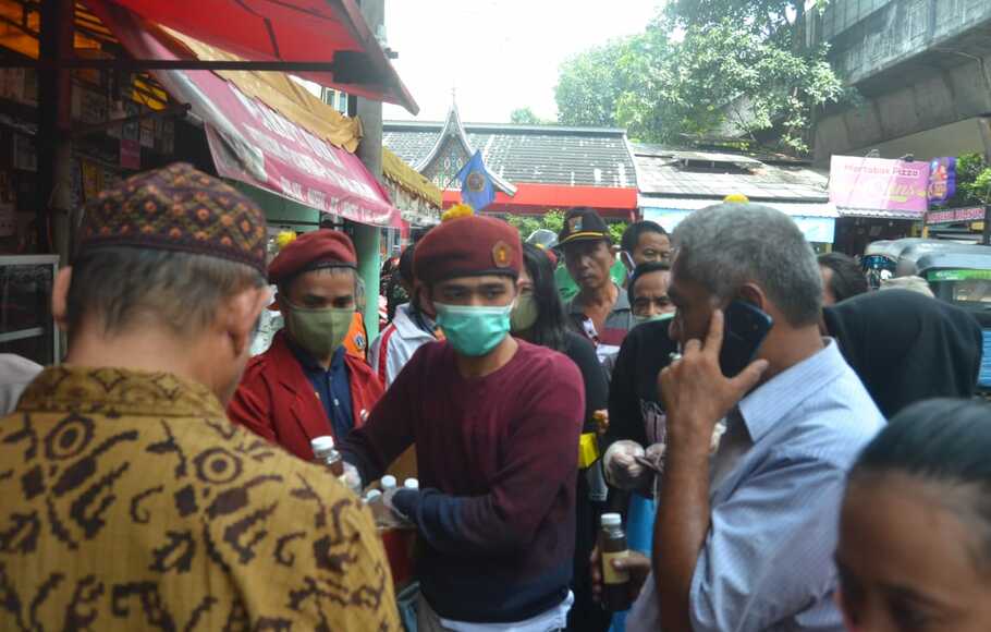 Para pengemudi ojek online (ojol), warga, dan pedagang kaki lima (PKL) di sekitar Stasiun Gondangdia, Menteng, Jakarta Pusat, Rabu (8/4), sedang menerima alat pelindung diri (APD) dari Satgas Covid-19 Forkoma-PMKRI.