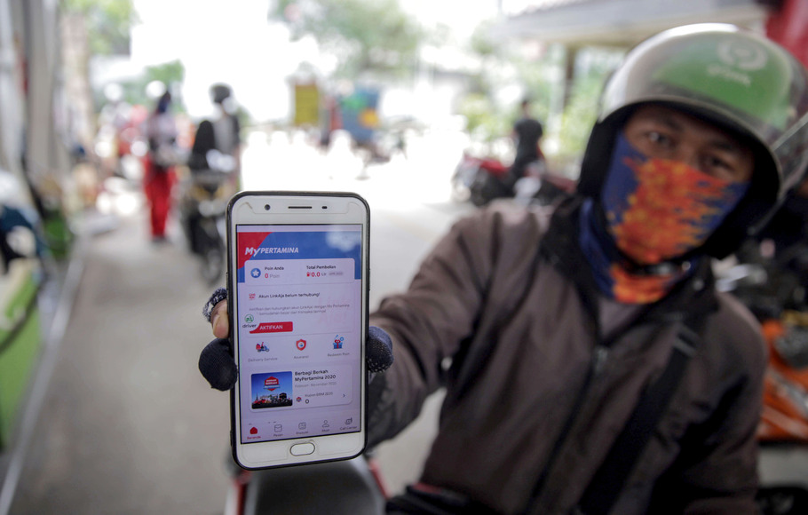 Pengemudi ojek online menunjukan aplikasi MyPertamina saat mengisi BBM di SPBU Pertamina di kawasan Cikini, Jakarta Pusat, Selasa, 14 April 2020.