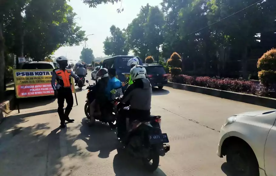 Seorang petugas nampak menyetop pengendara yang tidak menggunakan masker di Jalan Soleh Iskandar, Kota Bogor, Jumat, 17 April 2020.