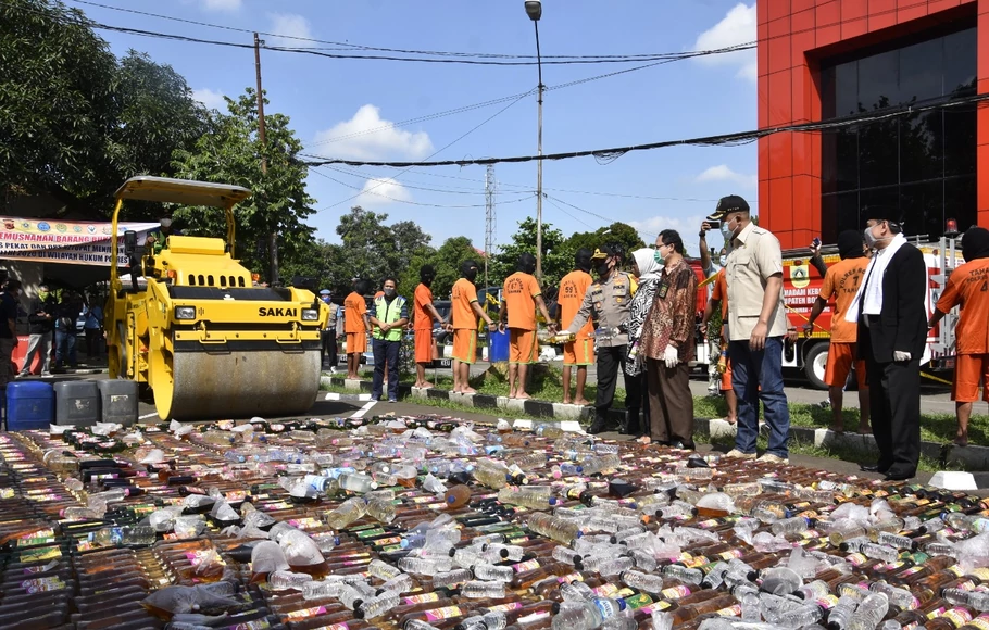 Kapolres Bogor AKBP Ronald Ronaldy memusnahkan ribuan botol minuman keras menggunakan kendaraan berat di Mapolres Bogor, Cibinong, Kabupaten Bogor, Jumat 22 Mei 2020.