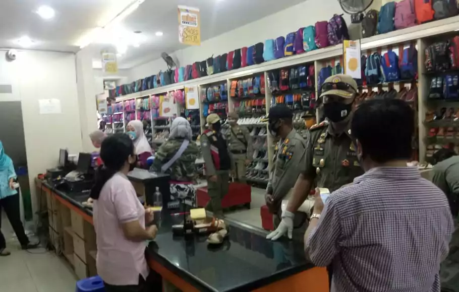 Petugas Satpol PP Kota Bogor menyegel toko pakaian di Pasar Anyar, Jalan MA Salmun, Kota Bogor, Sabtu (23/5/2020). Penyegalan dilakukan setelah tiga kali mendapat surat teguran.
