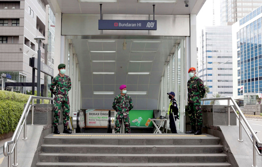 Prajurit TNI berjaga di depan pintu masuk Stasiun MRT Bundaran HI, Jakarta, Rabu, 27 Mei 2020.