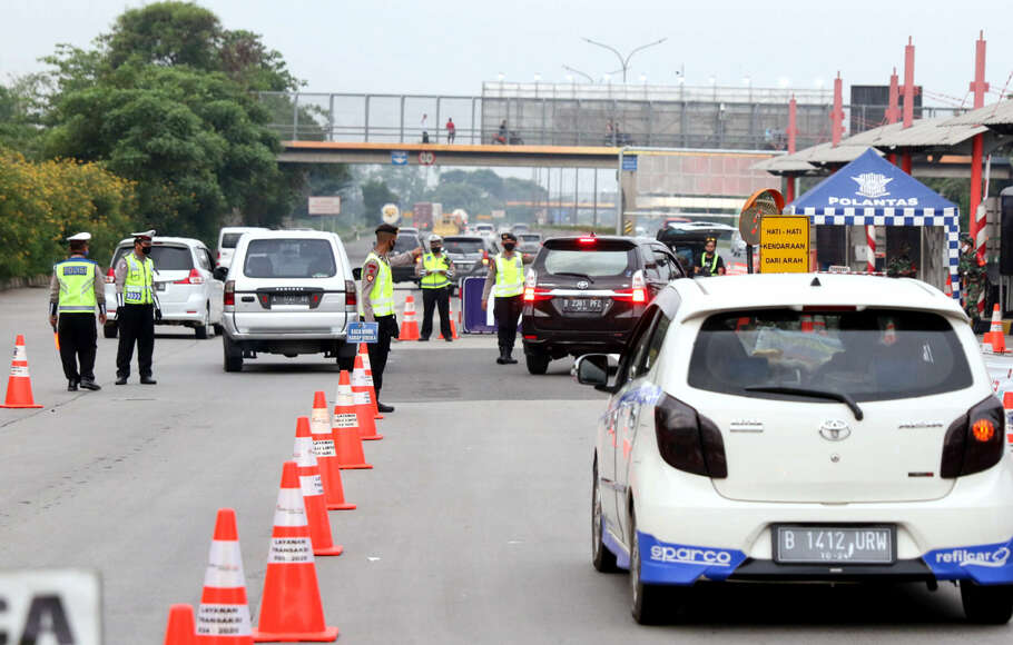 Petugas gabungan dari Kepolisian, Dinas Perhubungan, dan Satpol-PP saat melakukan pengecekan Surat Izin Keluar atau Masuk (SIKM) terhadap kendaraan yang akan memasuki wilayah Jakarta di gerbang tol Cikupa, Tanggerang, Jumat, 29 Mei 2020. 