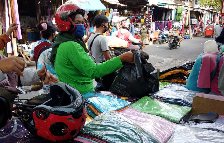 Pengunjung membawa barang belanjaan dengan kantong plastik di Pasar Jatinegara, Jakarta Timur, Selasa, 30 Juni 2020.