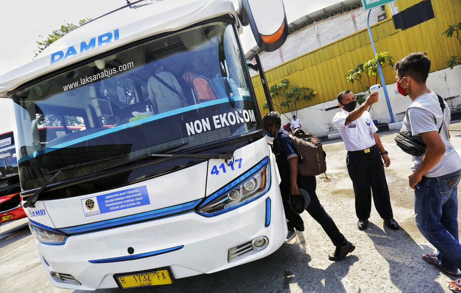 Petugas melakukan pengecekan suhu tubuh kepada penumpang bus Damri di Kemayoran, Jakarta, Senin, 27 Juli 2020.