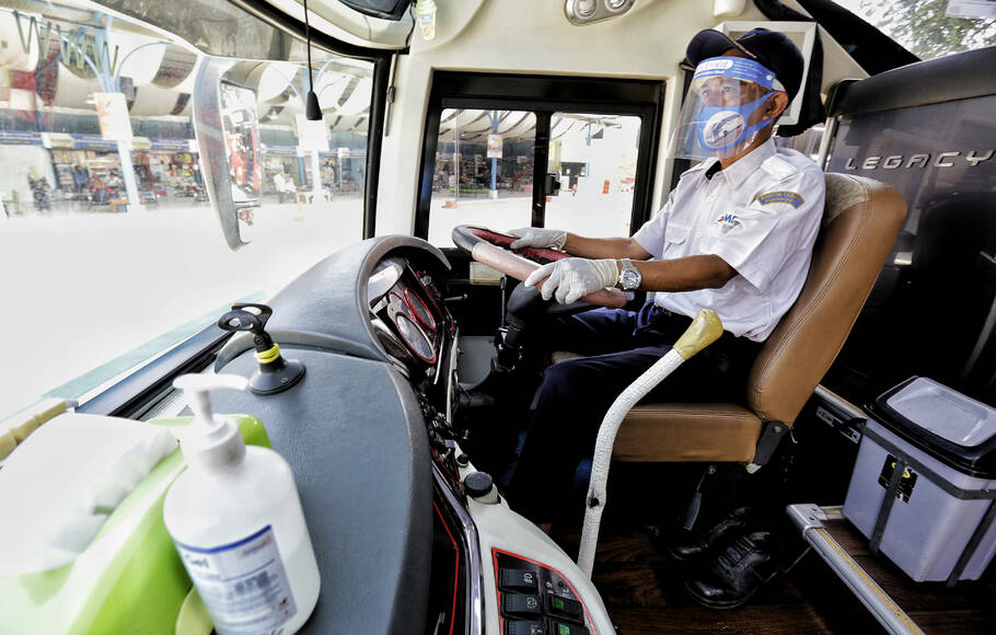 Juru mudi bus Damri menggunakan masker, sarung tangan dan Face Shield di Kemayoran, Jakarta, Senin, 27 Juli 2020.