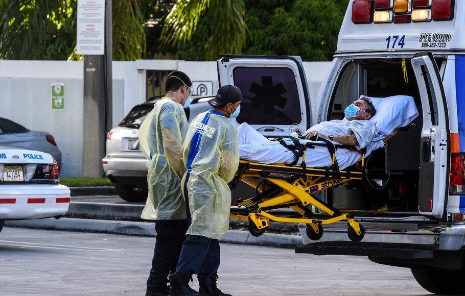 Paramedis memindahkan pasien terinfeksi Covid-19 di Miami, Florida, Amerika Serikat.