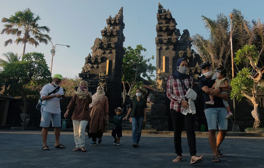 Wisatawan domestik menggunakan masker saat liburan Iduladha di masa adaptasi kebiasaan baru tahap II di objek wisata Tanah Lot, Tabanan, Bali, Sabtu 1 Agustus 2020. 
