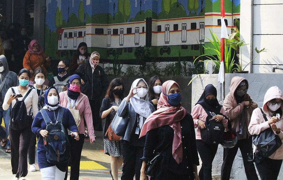 Penumpang commuterline memakai masker saat keluar dari Stasiun Sudirman, Jakarta Pusat.