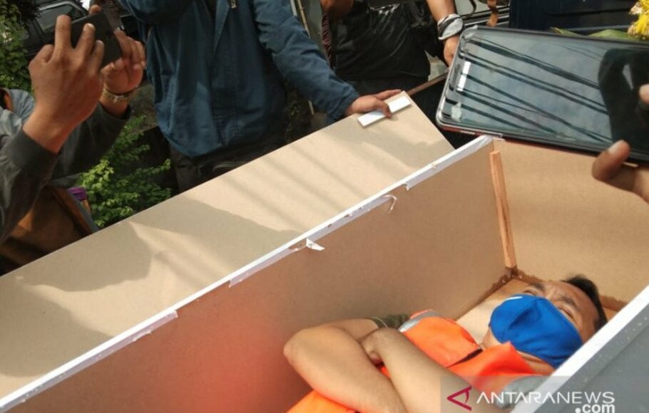 Seorang pelanggar protokol kesehatan di Kecamatan Pasar Rebo, Jakarta Timur, menjalani sanksi merenung di dalam peti jenazah usai terjaring razia petugas di Jalan Raya Bogor, Kamis (3/9/2020).