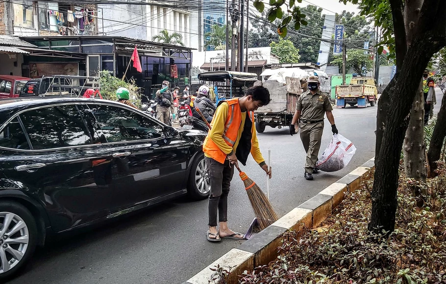 Warga yang melanggar protokol kesehatan dihukum menyapu jalan saat petugas gabungan menggelar razia penerapan protokol kesehatan di kawasan Lebak Bulus, Jakarta Selatan, Senin, 14 September 2020. 