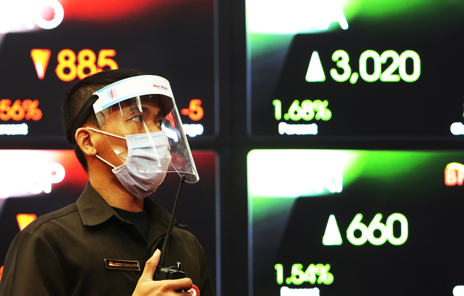 Petugas sedang berjaga dengan latar belakang indeks harga saham di Bursa Efek Indonesia, Jakarta.