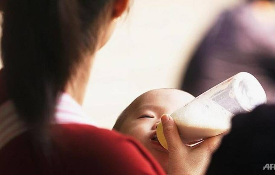 Ilustrasi: Seorang bayi sedang meminum susu dari botol plastik. 