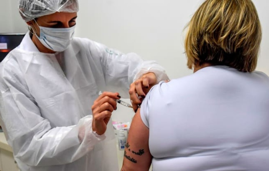 Dokter Monica Levi, salah satu relawan penerima vaksin Covid-19, bekerja di Klinik Khusus Penyakit Infeksi dan Parasit dan Imunisasi (CEDIPI), di Sao Paulo, Brasil, pada 24 Juli 2020. Dokter itu salah satunya dari 5.000 sukarelawan yang berpartisipasi pada uji coba fase 3 vaksin yang dikembangkan Universitas Oxford bersama dengan perusahaan farmasi Inggris AstraZeneca.

