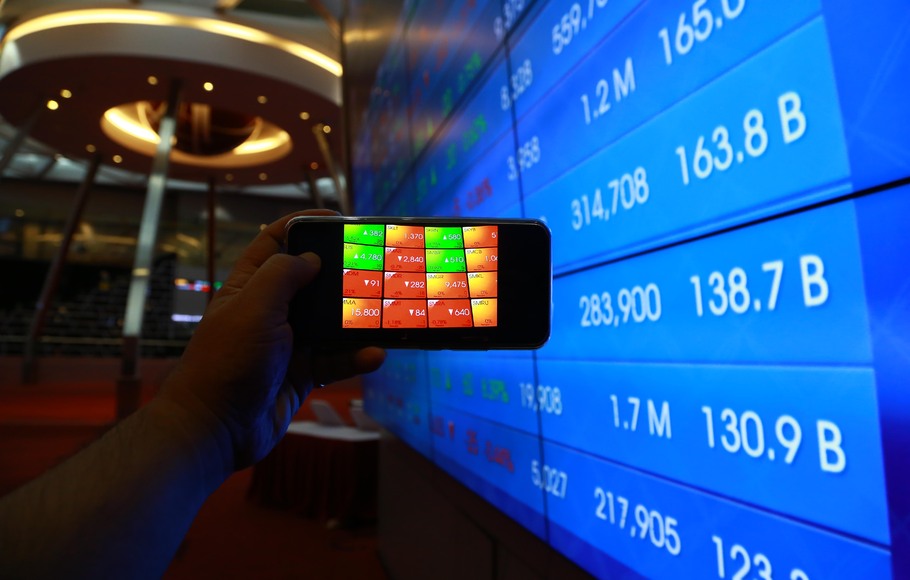 Pengunjung memotret menggunakan telepon genggam pergerakan harga saham di Bursa Efek Indonesia (BEI) di Jakarta.