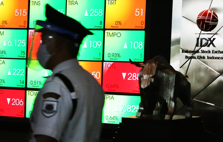 Petugas melintas di depan monitor perdagangan saham di Bursa Efek Indonesia (BEI) di Jakarta. 